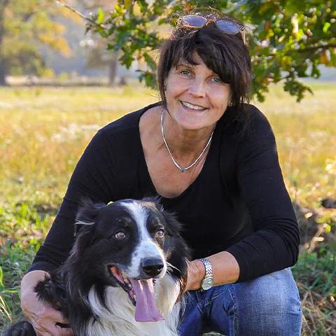 Britta Wehrmann mit ihrem Hund in freier Natur.