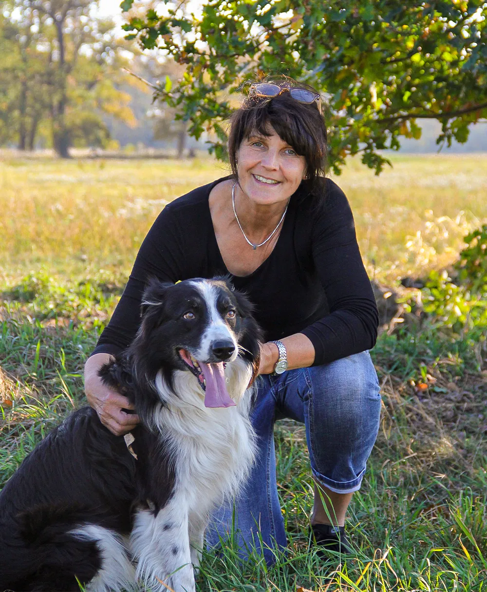 Britta Wehrmann mit ihrem Hund in freier Natur.